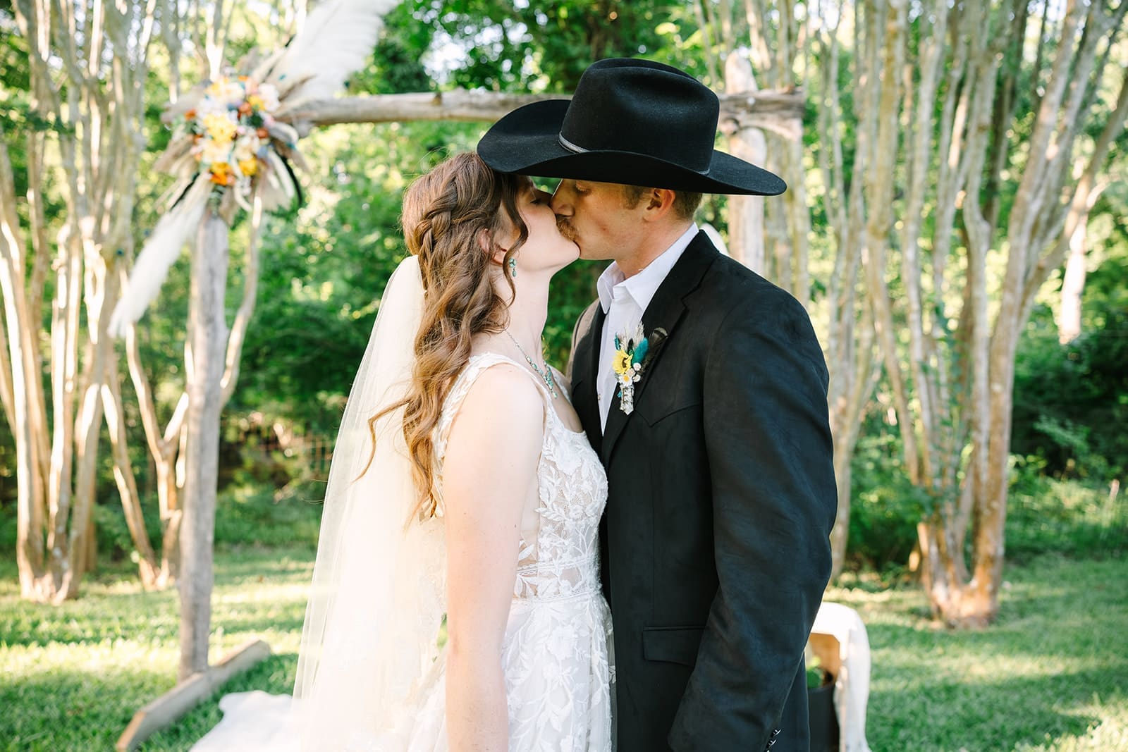 Chloe and Eli celebrating their newlywed moment with a kiss after their ceremony at Caney House in Ashwood, Texas.