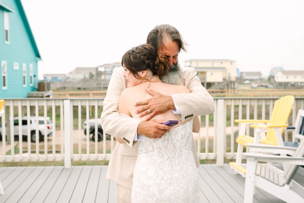 A bride embraces her father in a beautiful outdoor setting, showcasing a heartfelt moment shared between them.